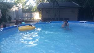 a woman is in a swimming pool with a raft at maison aux volets jaunes in Les Angles Gard +11 photos