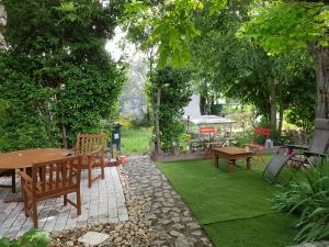 a garden with benches and a table and grass at maison aux volets jaunes in Les Angles Gard