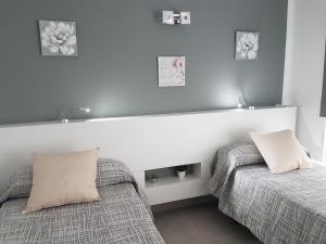dwa łóżka ustawione obok siebie w sypialni w obiekcie Vivienda Aries w Puerto del Carmen