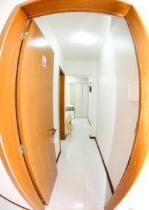 a hallway with a round wooden door and a mirror at Elsenau Hotel in Tabapira