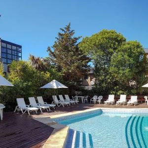 a pool with chairs and umbrellas next to a building at Tunkelen Carilo in Carilo