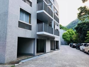 a building with cars parked in front of it at Hakone Yumoto Condominium Sakura with Hot Spring B-9 #Hs1 in Hakone