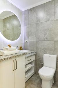 La salle de bains est pourvue de toilettes blanches et d'un miroir. dans l'établissement All Seasons Suites, à Istanbul