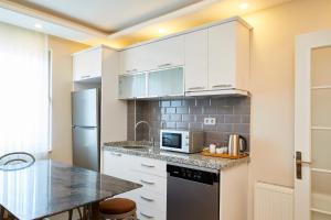 a kitchen with white cabinets and a counter top at All Seasons Suites in Istanbul