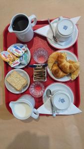 un vassoio rosso con prodotti per la colazione e una tazza di caffè di Hotel KEY´S a Buenos Aires