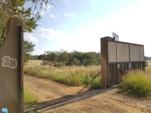 una puerta abierta en un camino de tierra en un campo en CHEETAH MANOR #2 en Bloemfontein
