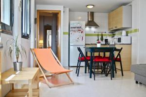 a small kitchen and dining room with a table and chairs at Apartamento PUERTA-CALETA by Cadiz4Rentals in Cádiz