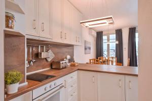 a kitchen with white cabinets and a counter top at South Park, Vitosha View, 2-BDR, 2-BTHR Apartment in Sofia
