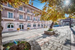 un grand bâtiment rose dans une rue de la ville dans l'établissement Hotel Kastoria in Kastoria City, à Kastoria