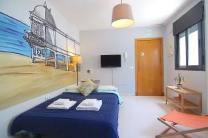 a bedroom with a blue bed with a painting on the wall at Apartamento PUERTA-CALETA by Cadiz4Rentals in Cádiz