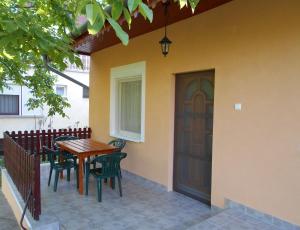 a patio with a wooden table and chairs next to a door at Zsuzsi Apartman in Zalakaros