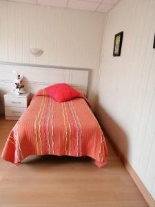 a bed with a red pillow in a bedroom at Hotel A Santiago in Belorado