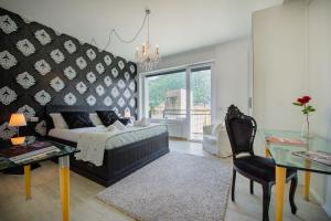 コモにあるVictoria Apartmentのベッドとテーブルと椅子のある寝室