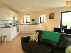 a living room with a couch and a kitchen at Sail Boats in Marazion
