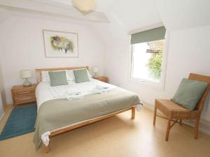 a bedroom with a large bed and a window at White Duck Cottage in Hayle