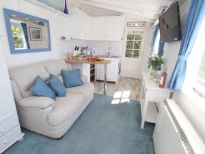 a living room with a couch and a kitchen at Studio in Polperro