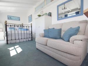 a living room with a couch and a bed at Studio in Polperro