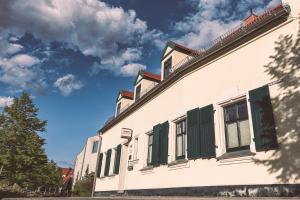 ein Gebäude mit grünen Fensterläden an der Seite in der Unterkunft Hotel-Pension Mandy - Adults Only in Senftenberg