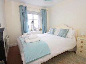 a bedroom with a bed with towels on it at Driftwood Cottage in St Austell