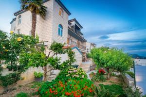 a building with flowers and plants in front of it at Apartments Katarina with swimming pool in Stobreč