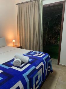 a bedroom with a bed with a blue and white blanket at Apartamento A-11 Pipa Beleza Resort in Pipa +69 photos