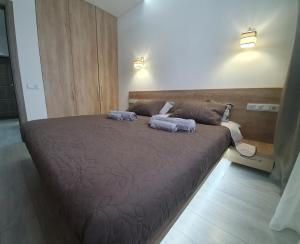 a bedroom with a large bed with two towels on it at LuxApartment in Kyiv