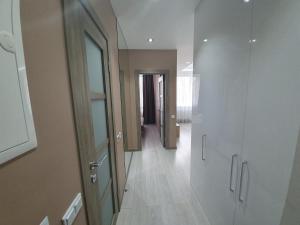 a hallway with white walls and wooden floors and a door at LuxApartment in Kyiv +14 photos