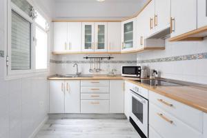 a white kitchen with white cabinets and a sink at Santa Cruz Bolívar Experience in Santa Cruz de Tenerife