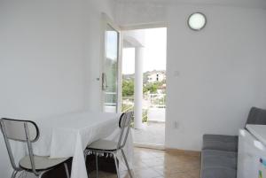 a dining room with a white table and chairs at Hit apartment in Sevid