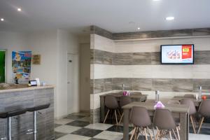 a restaurant with tables and chairs and a tv on the wall at Greta Apartments in Hersonissos
