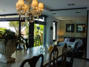 Un comedor con una mesa y una lámpara de araña. en Belvilla by OYO Villa Catro Faros, en Montalvo
