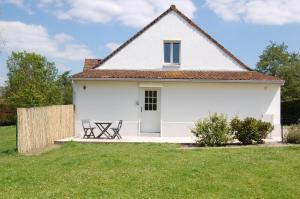 une maison blanche avec une table de pique-nique dans une cour dans l'établissement Chez Poussin, à Verton