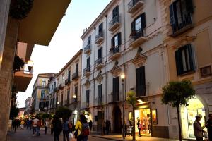a group of people walking down a street with buildings at Le Suite del Duomo in Cava deʼ Tirreni