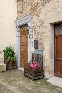 une porte en bois avec des fleurs devant un bâtiment dans l'établissement Le Vecchie Mura Apartment, à Cannara