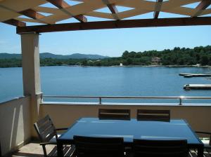 einen Tisch und Stühle auf einem Balkon mit Seeblick in der Unterkunft Apartments Ivo - terrace with sea view in Veli Rat