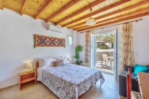 a bedroom with a bed and a balcony at Jewel Apartments Mykonos in Ornos