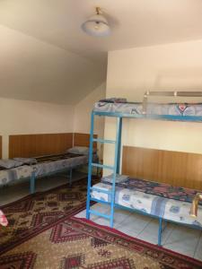 a room with three bunk beds and a rug at Camping Paradisul Soferilor in Onești