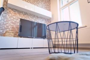 a black chair in a living room with a tv at Apartament Kalinka in Nysa