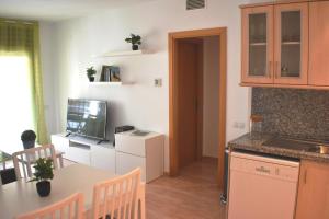 Apartament Sergi في أمبوستا: مطبخ وغرفة طعام مع طاولة وتلفزيون