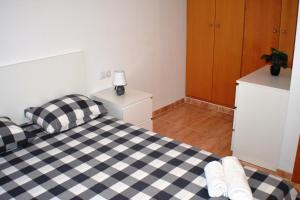 1 dormitorio con cama a cuadros en blanco y negro en Apartament Sergi, en Amposta