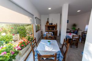 un comedor con mesa, sillas y flores en Villa Nertili, en Ksamil