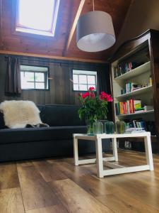 a living room with a couch and a table with flowers at Onder de Appelboom in Garminge