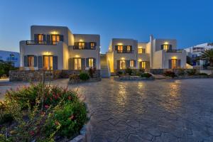 a large white house at night with lights on at Jewel Apartments Mykonos in Ornos