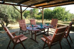 a wooden table and chairs on a patio at Limnos Stone House in Kalliópi