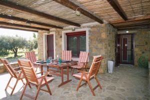 a wooden table and chairs on a patio at Limnos Stone House in Kalliópi