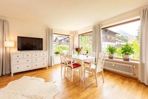 a dining room with a table and chairs and a television at Ferienwohnung Jasmin in Oberstdorf