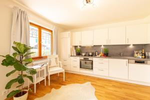 a kitchen with white cabinets and a table and a plant at Ferienwohnung Jasmin in Oberstdorf