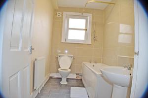 a bathroom with a toilet and a tub and a sink at Kensington Guest House Liverpool in Liverpool