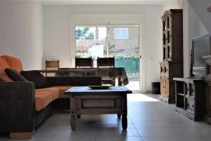 een woonkamer met een bank en een piano bij Villa Llobeta in L'Ametlla de Mar