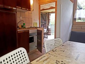 kuchnia ze stołem i krzesłami oraz kuchnia z kuchenką w obiekcie Apartma NADIŽA Borjana107 w mieście Borjana